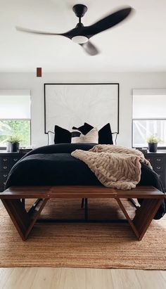 a bed with black sheets and pillows in a room