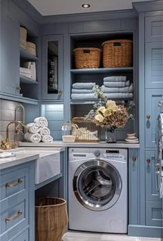 a washer and dryer in a blue laundry room with lots of storage space