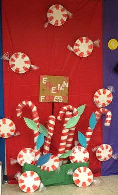 the candy canes are on display in front of red and blue door with paper decorations