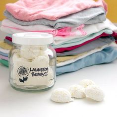 a jar filled with laundry powder next to several folded ones