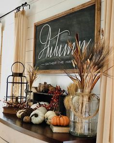 an autumn display with pumpkins, gourds and other items on a table