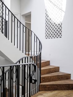 a spiral staircase with metal railing and wooden steps