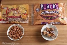 two bowls filled with cereal and nuts next to bags of snacks on a wooden table