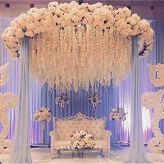 an elegant wedding setup with white flowers and blue drapes