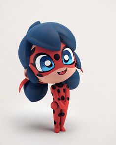 a red and black figurine with big blue eyes on it's head