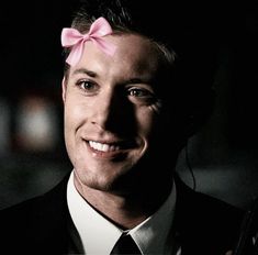 a man wearing a pink bow tie in the dark