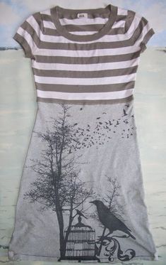 a t - shirt that has a bird on it and a tree in the background