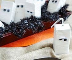 a table topped with black and white halloween decorations on top of a cloth covered table