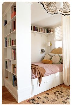 there is a bed in the room with bookshelves on both sides and a rug on the floor