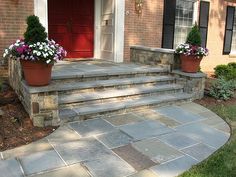 two flower pots on the front steps of a house