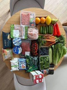 a wooden table topped with lots of different types of foods and vegtables