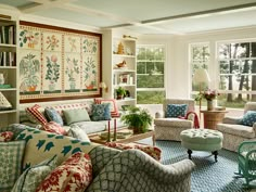 a living room filled with lots of furniture and decor on top of a blue rug