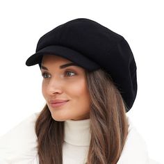 a woman wearing a black hat and white turtle - neck sweater is posing for the camera