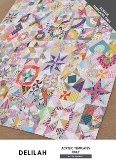 a quilt made with colorful fabrics on top of a cardboard box and the words delilah above it