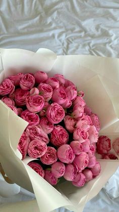 a bouquet of pink flowers sitting on top of a bed