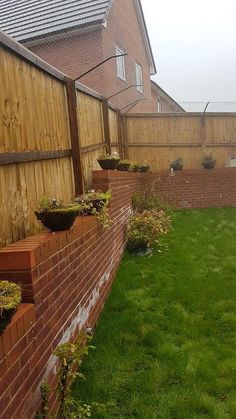 the back yard is fenced off and has grass growing in pots on each side