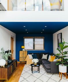 a living room with blue walls and white rugs on the hardwood flooring is shown