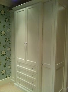 a white closet with floral wallpaper in a room