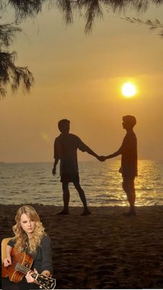 two people holding hands while standing on the beach with sunset behind them and one person playing an acoustic guitar