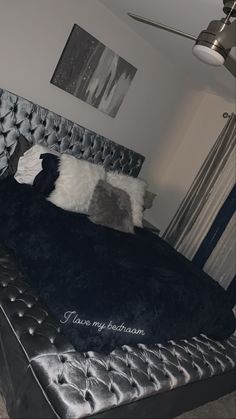 there is a bed that has been made with black and white pillows on it,