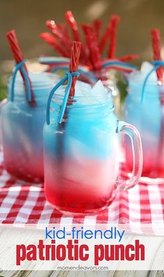 two glasses filled with patriotic punch sitting on top of a checkered table cloth and red white and blue straws