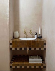 there is a sink in the corner of this bathroom with tile on the floor and walls