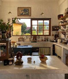 a kitchen filled with pots and pans on top of a counter next to a window