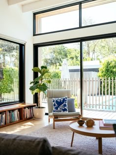 a living room filled with furniture next to a large sliding glass door that opens onto a pool