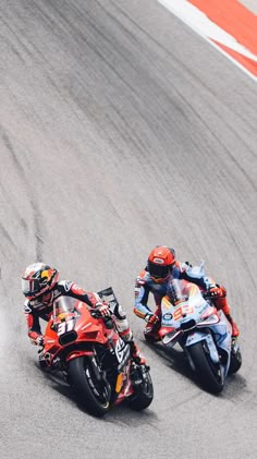 two motorcyclists racing on a race track in the same direction as each other