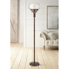 a floor lamp with two lights on it in a living room next to a couch