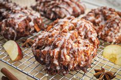 apple cinnamon muffins on a cooling rack with an apple and cinnamon stick next to them