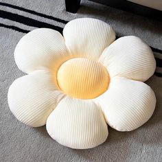 a white flower sitting on top of a rug