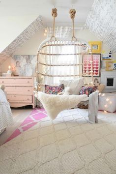 a bedroom with a hanging bed and white rugs on the floor in front of it