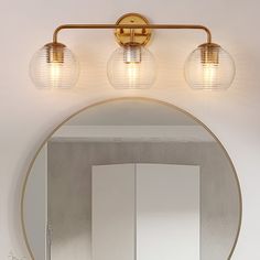 a bathroom vanity with three lights and a mirror