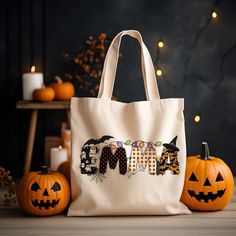 a white bag sitting on top of a table next to pumpkins