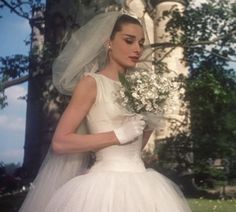 a woman in a wedding dress holding flowers