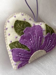 a heart shaped ornament with purple flowers on it