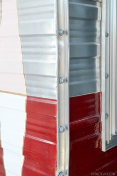 a red, white and silver trailer door with metal studs on it's side