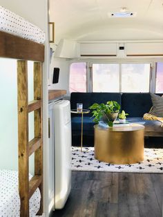 a living area with bunk beds and a couch in the corner, next to a window