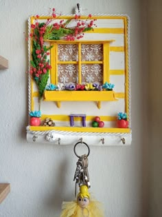 a keychain hanging from the side of a wall with a window on it