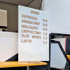 a white sign sitting on top of a wooden table next to a freezer oven