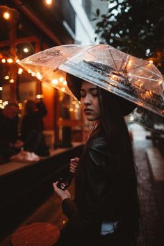 a woman holding an umbrella on the street