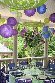 an outdoor dining area with purple and green decorations