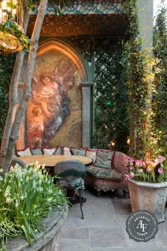 an outdoor living area with couches and potted plants on the ground, surrounded by greenery