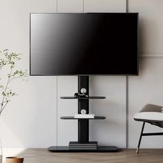 a flat screen tv mounted to the side of a wall next to a chair and potted plant