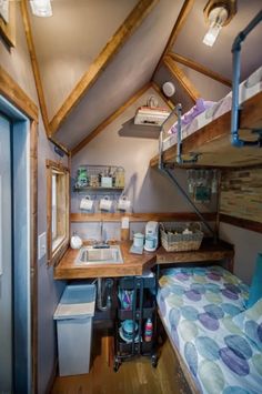 a small room with a bed, sink and bunk beds in it's corner