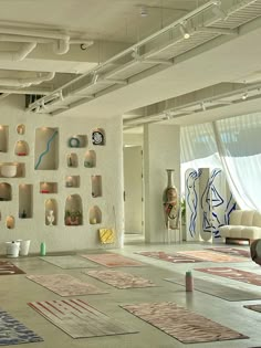 a large room with lots of rugs on the floor and walls covered in artwork