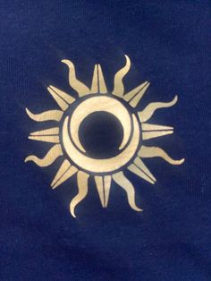 a blue shirt with an image of the sun on it