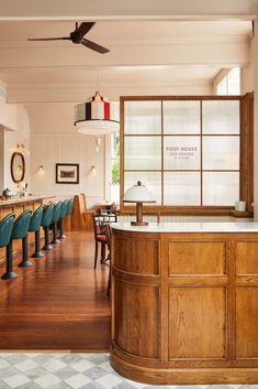 an empty bar with blue chairs and wooden counter tops in a restaurant or hotel lobby