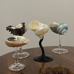 three wine glasses sitting on top of a wooden table